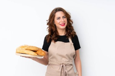 Şef üniformalı kadın. Kadın fırıncı elinde birkaç ekmeğin bol bol gülümsediği bir masa tutuyor.