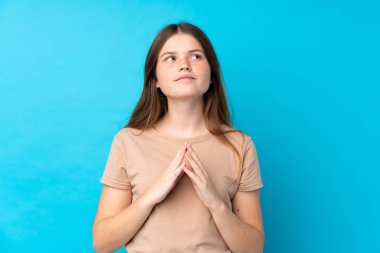 Ukraynalı genç kız izole edilmiş mavi arka plan entrikaları kuruyor.