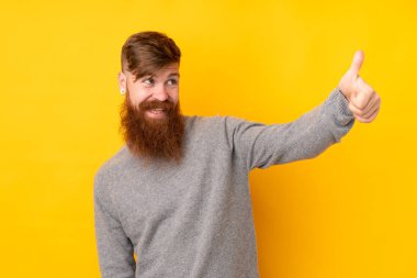 Kızıl saçlı, uzun sakallı, izole edilmiş sarı arka planlı bir adam.