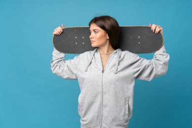 İzole edilmiş mavi arka planı olan genç bir kadın.