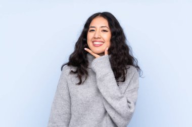 İzole edilmiş mavi arka planda gülümseyen İspanyol Çinli kadın