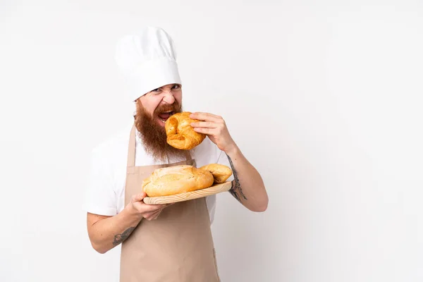 Un rouquin en uniforme de chef. Boulanger masculin tenant une table avec sev — Photo