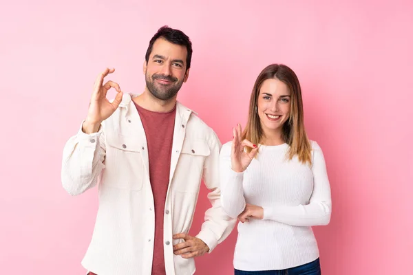 Para Walentynki Nad Odizolowanym Różowym Tle Pokazując Znak Palcami — Zdjęcie stockowe