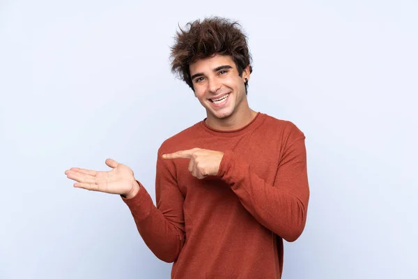 Joven Hombre Caucásico Sobre Fondo Azul Aislado Sosteniendo Espacio Copia —  Fotos de Stock