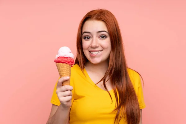 Roodharige tiener meisje met een cornet ijs over geïsoleerde achtergrond — Stockfoto
