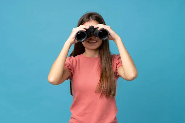 Mujer Joven Sobre Fondo Azul Aislado Con Binoculares Negros —  Fotos de Stock