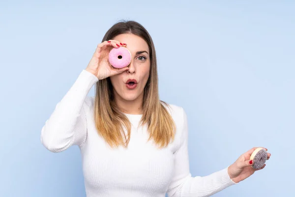 Junge Blonde Frau Über Isoliertem Blauem Hintergrund Hält Einen Donut — Stockfoto