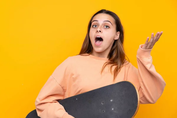 Jeune fille patineuse sur fond jaune isolé — Photo