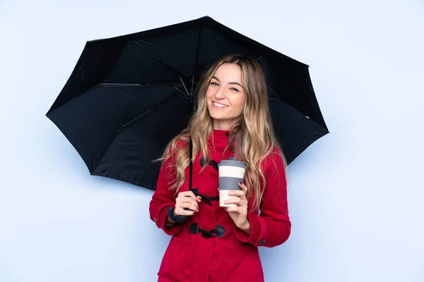 Jeune femme avec manteau d'hiver tenant un parapluie et un café pour — Photo