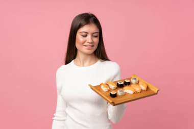 Sushi 'si olan genç bir kız soyutlanmış pembe bir geçmişi ve mutlu bir ifadesi var.