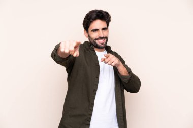 Arka planda sakallı genç yakışıklı adam gülümserken seni işaret ediyor.