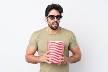 Sakallı yakışıklı, soyutlanmış beyaz bir geçmişi olan, 3D gözlüklü ve elinde koca bir kova patlamış mısırla şaşırmış genç bir adam.