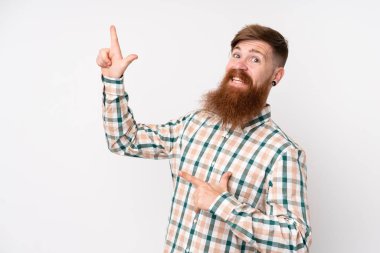 Uzun sakallı, soyutlanmış beyaz arkaplanı olan kızıl saçlı adam işaret parmağıyla işaret ediyor. Harika bir fikir.