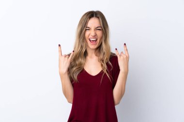 İzole edilmiş beyaz arka planda genç bir kadın kaya hareketi yapıyor.