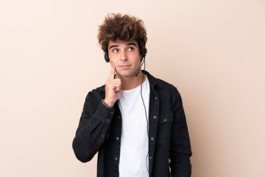 Tele pazarlamacı, izole edilmiş arka plan üzerinde çalışan bir kulaklıkla bir fikir düşünüyor.