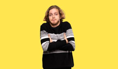 Sarışın adam, renkli arka planda omuzlarını kaldırırken şüpheli hareketler yapıyor.