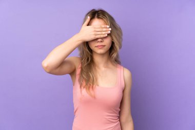 Mor arka planda izole edilmiş genç Rus kız gözlerini elleriyle kapatıyor. Bir şey görmek istemiyorum.