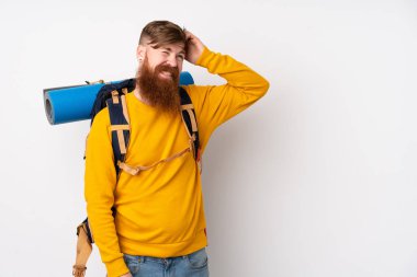 İzole edilmiş beyaz arka plan üzerinde büyük bir sırt çantasıyla genç dağcı adamın şüpheleri ve kafası karışmış bir yüz ifadesi var.