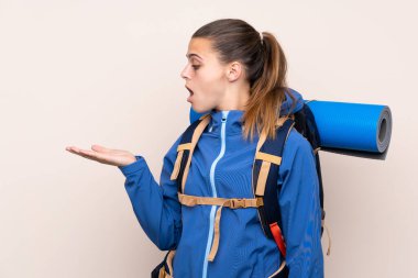 Arka planda izole edilmiş büyük bir sırt çantasıyla genç dağcı kız.