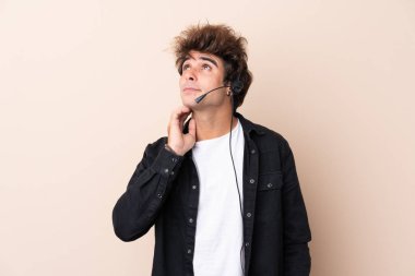 Tele pazarlamacı, izole edilmiş arka plan üzerinde çalışan bir kulaklıkla bir fikir düşünüyor.