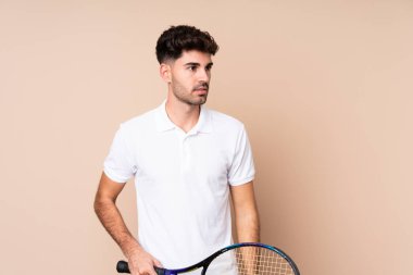 Tenis oynayan soyutlanmış genç adam.