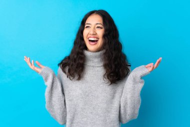 İspanyol Çinli kadın, izole edilmiş mavi arka planda gülümsüyor.