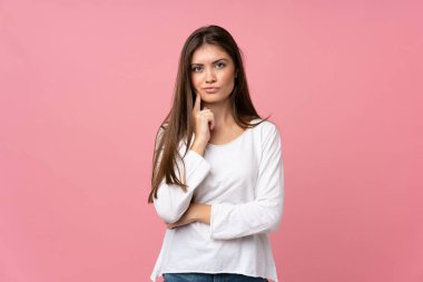 Soyutlanmış pembe arka planda genç bir kadın.