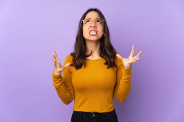 Mor arka planda izole edilmiş genç melez kadın kötü bir durum yüzünden hayal kırıklığına uğradı.