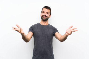 Genç yakışıklı, soyutlanmış beyaz bir arka plan sunuyor ve davet ediyor.