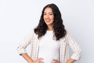 Karma ırk kadını, soyutlanmış beyaz arka planda kolları kalçasında ve gülümsüyor.