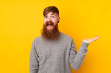 Uzun sakallı, sarı arka planda kızıl saçlı bir adam. Avucunun içinde hayali bir şey tutuyor. Bir ilan vermek için.