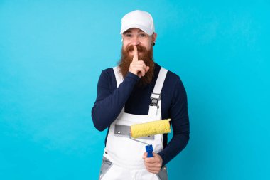 Uzun sakallı ressam, izole edilmiş mavi arka planda sessizlik hareketi yapıyor.