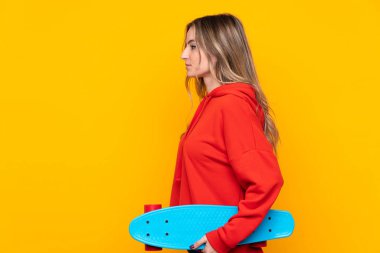 İzole edilmiş sarı arka planı olan genç bir kadın.