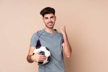 Futbol topunun zaferini kutlayan izole bir geçmişi olan genç bir adam.