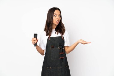 Beyaz arka planda yalıtılmış genç kuaför kadın. Şaşırtıcı yüz ifadesi var.