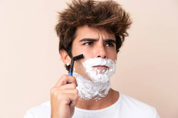 Jovem homem bonito barbeando sua barba — Fotografia de Stock