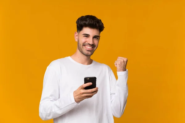Zole Edilmiş Turuncu Arka Planı Olan Genç Adam Telefon Zafer — Stok fotoğraf
