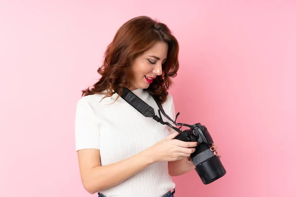 Joven Mujer Rusa Sobre Fondo Rosa Aislado Con Una Cámara —  Fotos de Stock