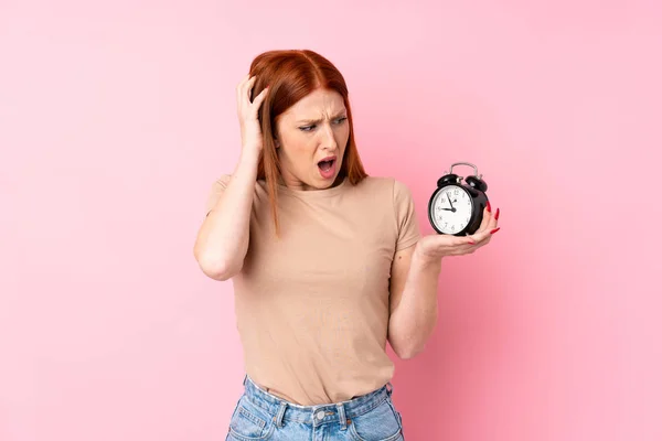 Joven Pelirroja Sobre Fondo Rosa Aislado Sosteniendo Reloj Despertador Vintage — Foto de Stock