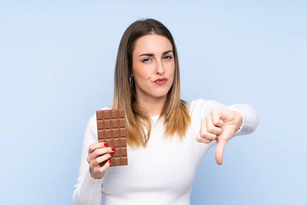 Mladá Blondýnka Žena Přes Izolované Modré Pozadí Čokoládovou Tabletu Dělat — Stock fotografie