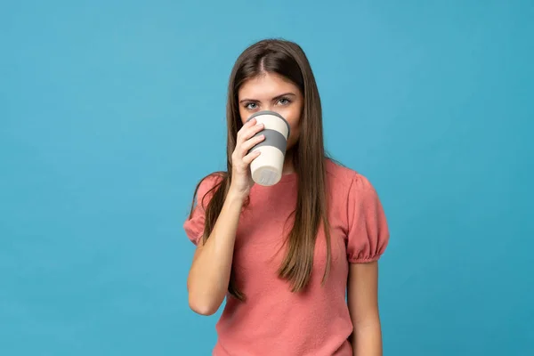 Mujer Joven Sobre Fondo Azul Aislado Sosteniendo Bebiendo Café Para —  Fotos de Stock