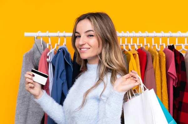 Mujer joven en una tienda de ropa con una tarjeta de crédito y con s —  Fotos de Stock