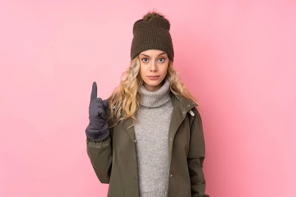 Jong Meisje Met Winter Hoed Geïsoleerd Roze Achtergrond Wijzend Met — Stockfoto