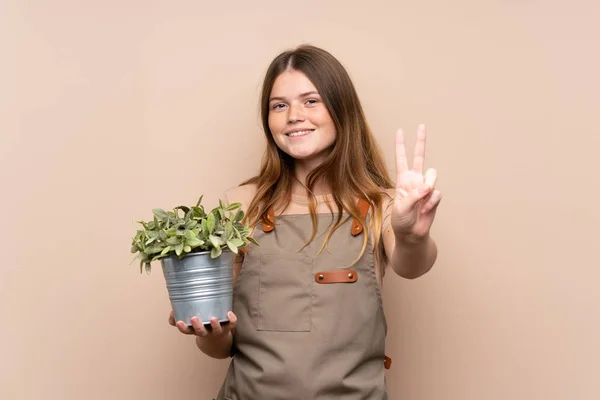 Adolescente Ucraniana Jardinero Chica Sosteniendo Una Planta Sonriendo Mostrando Signo — Foto de Stock