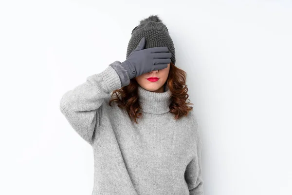 俄罗斯年轻女子 头戴冬帽 手捂着眼睛 遮住白色的孤立背景 — 图库照片