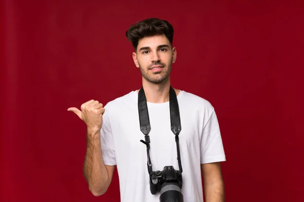 Mladý Muž Nad Izolovaným Pozadím Profesionální Kamerou Ukazuje Strany — Stock fotografie
