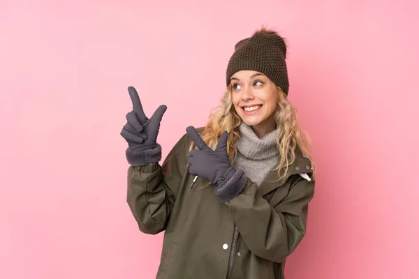 Jong Meisje Met Winter Hoed Geïsoleerd Roze Achtergrond Wijzend Met — Stockfoto