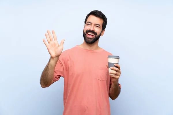 Jongeman Met Baard Houdt Een Take Away Koffie Geïsoleerde Blauwe — Stockfoto