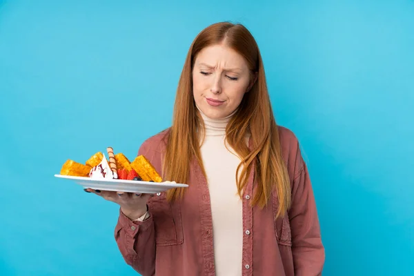 Young Redhead Woman Holding Waffles Isolated Background Sad Expression — Stock Photo, Image