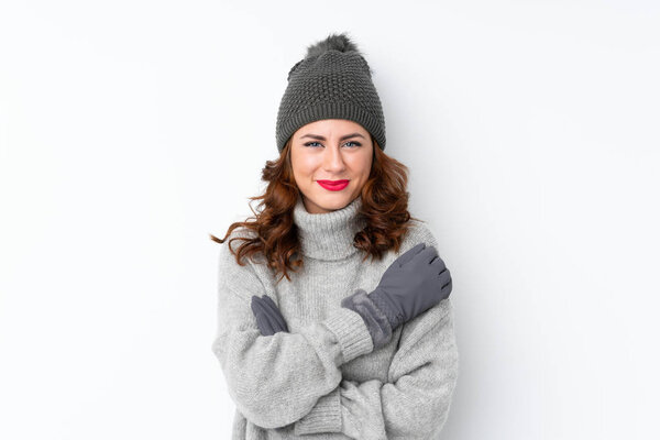 Young Russian woman with winter hat over isolated white background laughing